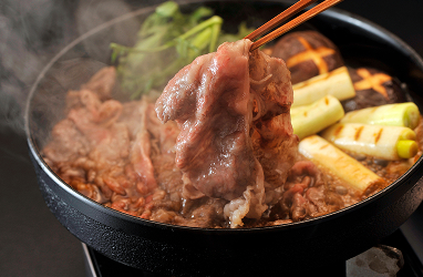 Sukiyaki beef and vegetables cooked in a steaming pot
