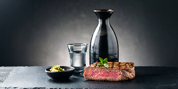 A set of perfectly cooked steak and sake